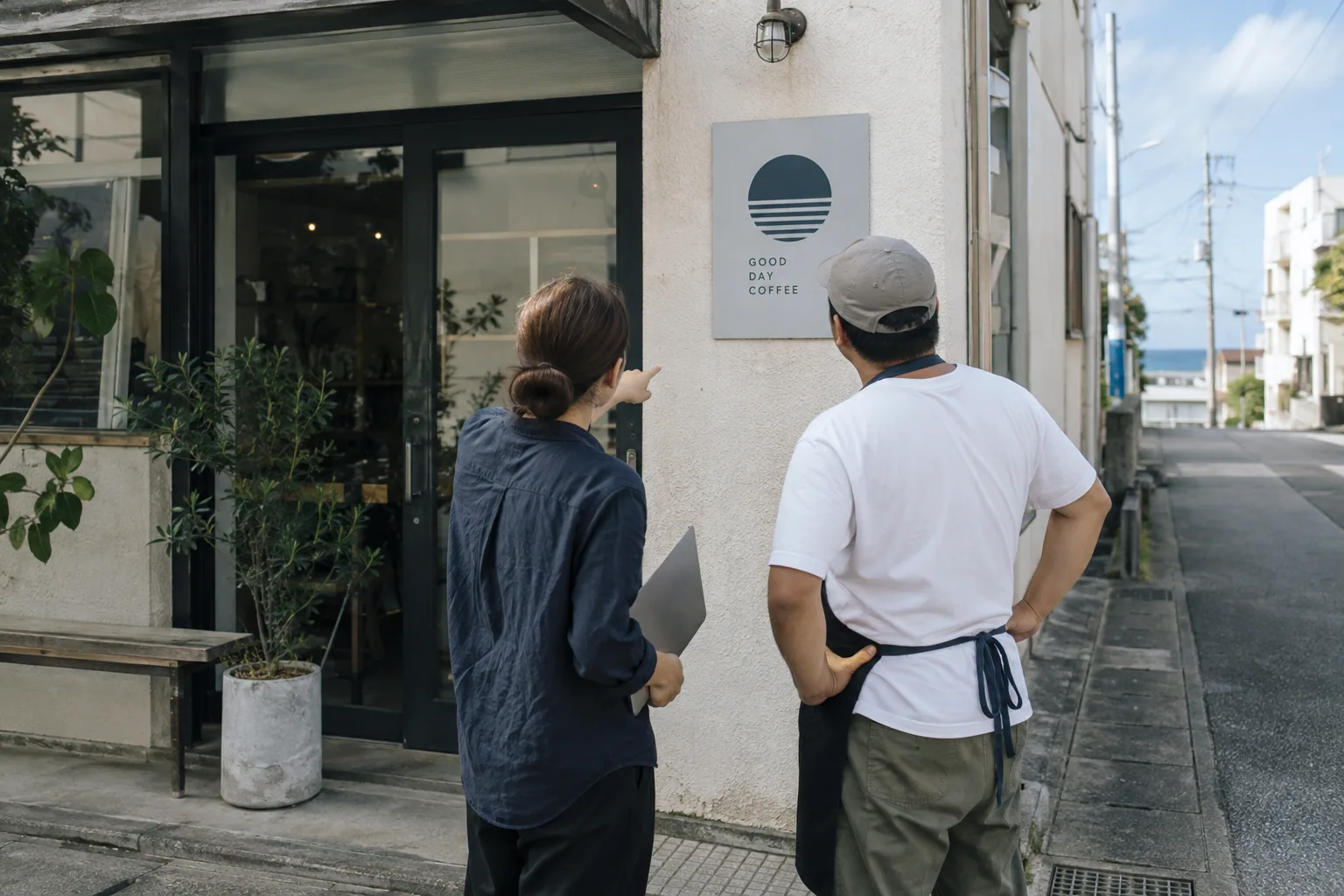 店舗の外で看板の見え方を相談する二人の生成イメージ